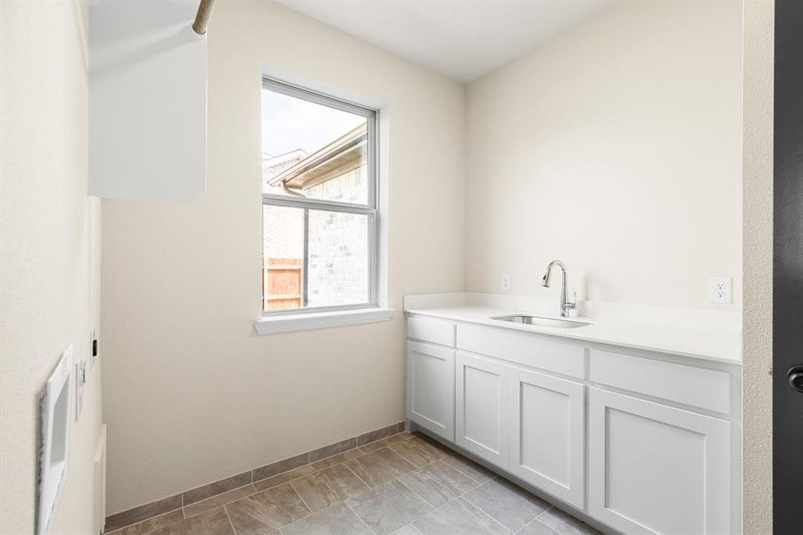 Washroom featuring sink and light tile patterned flooring