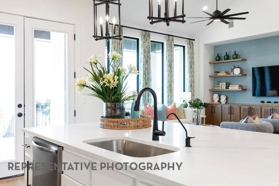 Kitchen featuring a sink, dishwasher, a chandelier, open floor plan, and white cabinetry