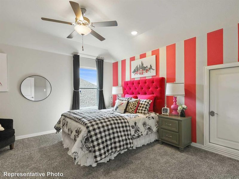 Carpeted bedroom featuring a ceiling fan with integrated lighting, a window with dark drapery, a paneled door, and a wall with vertical red and white stripes