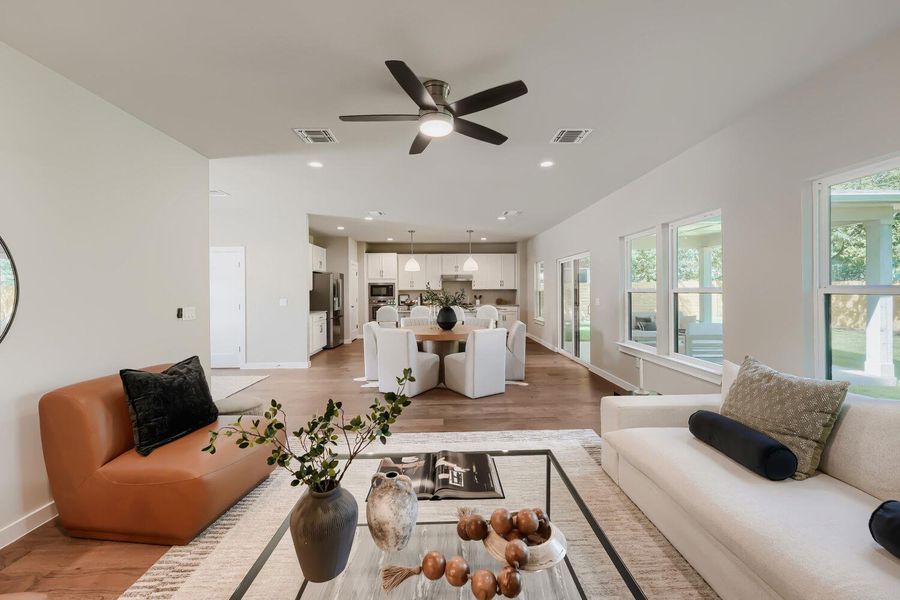 Hardwood floors flow through this sun-drenched living space, connecting kitchen, dining, and living areas. Hardwood floors flow through this sun-drenched living space, connecting kitchen, dining, and living areas.