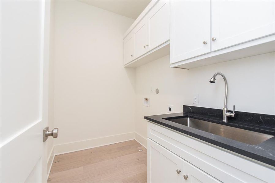 Laundry room located on the second floor with large utility sink.