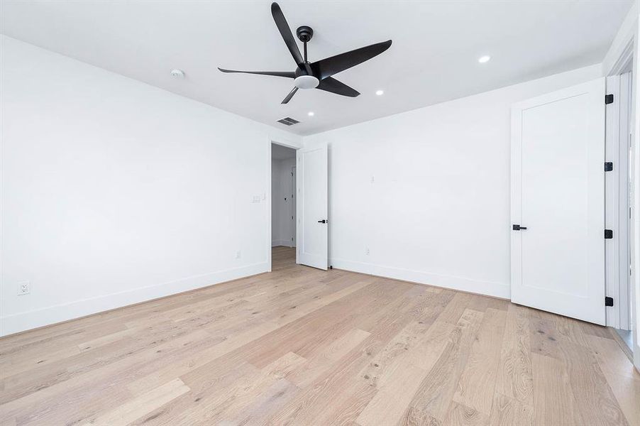 This is a modern kitchen featuring sleek dark wood cabinetry, white countertops, stainless steel appliances, and stylish pendant lighting. The space is bright and well-lit, with a clean and contemporary design.