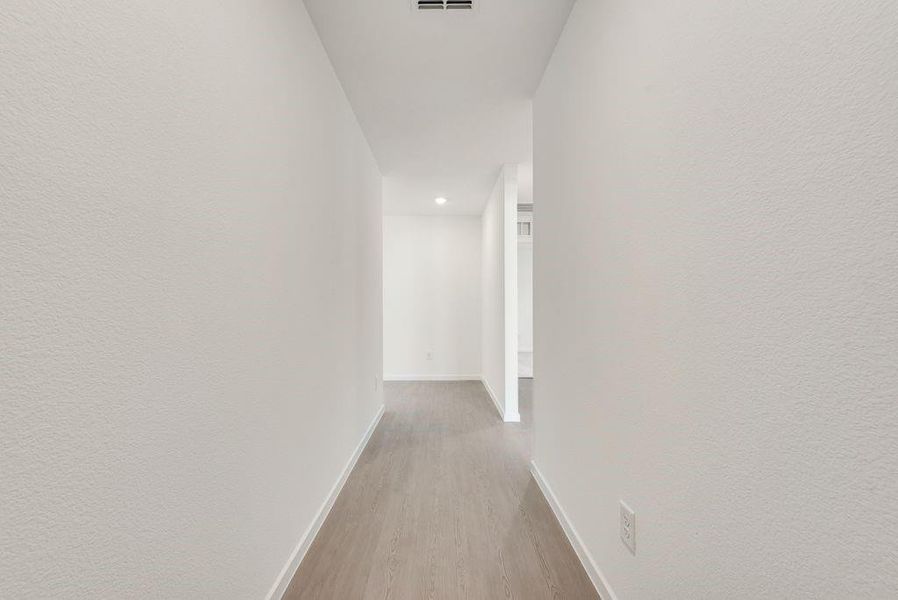 Hall featuring visible vents, baseboards, and wood finished floors