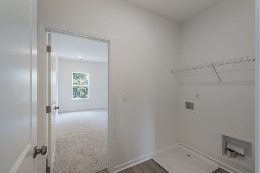 Laundry room with access to the primary bedroom.