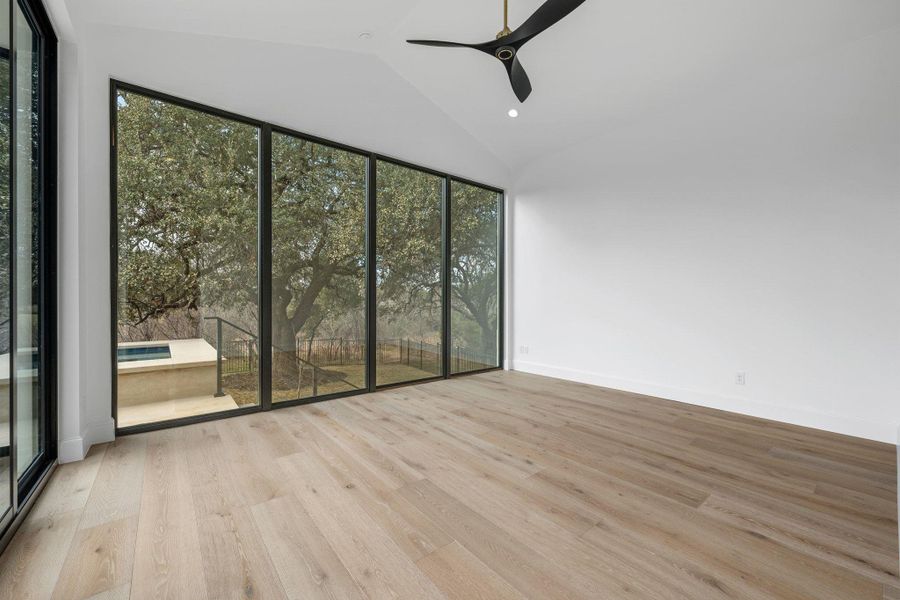 Spare room featuring a ceiling fan, vaulted ceiling, light wood-type flooring, and recessed lighting