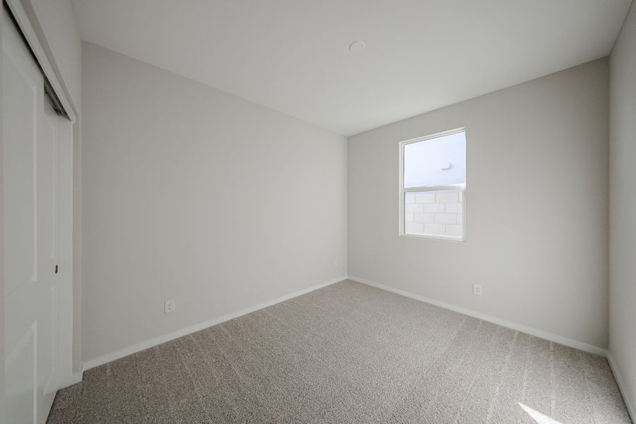 A room with a carpet and a white door. A room with a carpet and a white door.