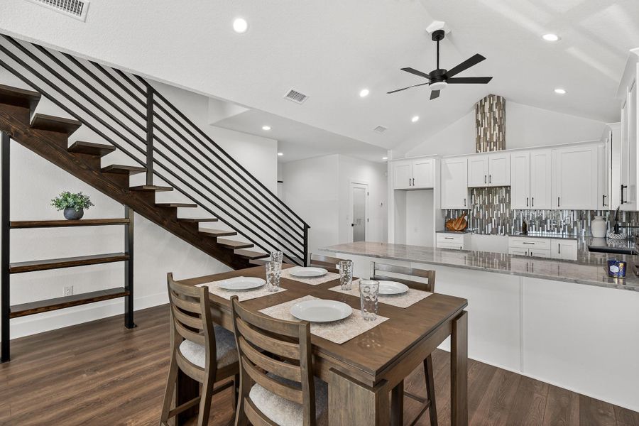 Dining space with stairway, dark wood-style floors, vaulted ceiling, recessed lighting, and ceiling fan Dining space with stairway, dark wood-style floors, vaulted ceiling, recessed lighting, and ceiling fan
