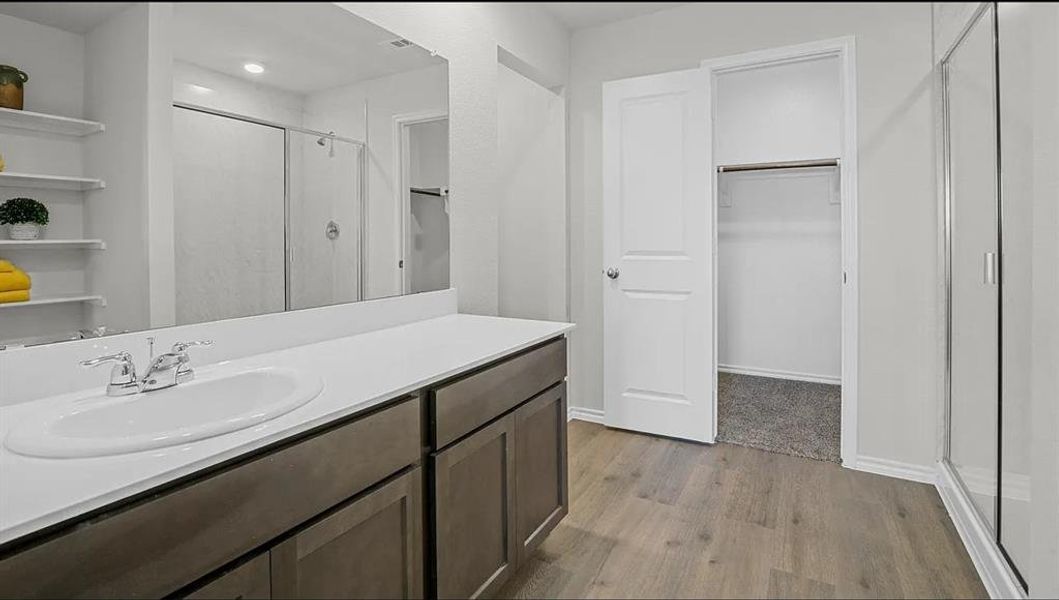 Bathroom featuring vanity, hardwood / wood-style floors, and walk in shower