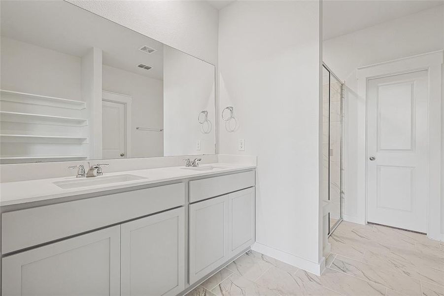 Bathroom featuring vanity and a shower with shower door