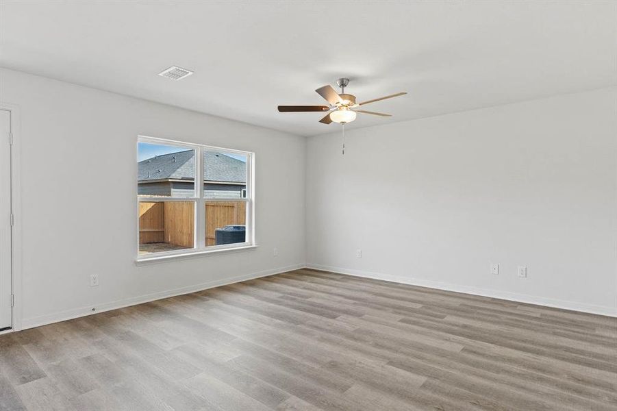 Empty room featuring light wood-type flooring and ceiling fan