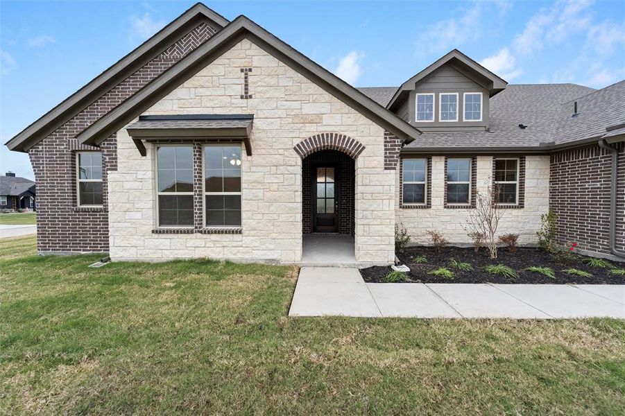 View of front of house featuring a front lawn, stone siding, and roof with shingles View of front of house featuring a front lawn, stone siding, and roof with shingles