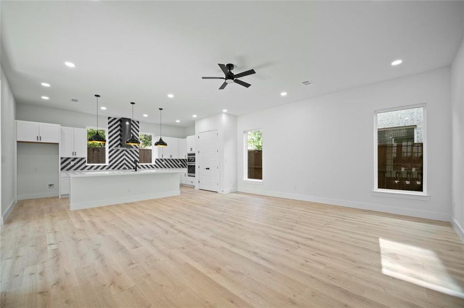 Unfurnished living room featuring a ceiling fan, light wood finished floors, and recessed lighting