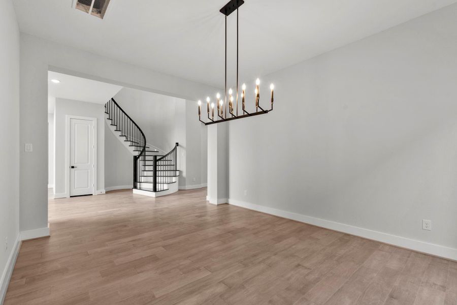 A view of the curved staircase through the formal dining area.