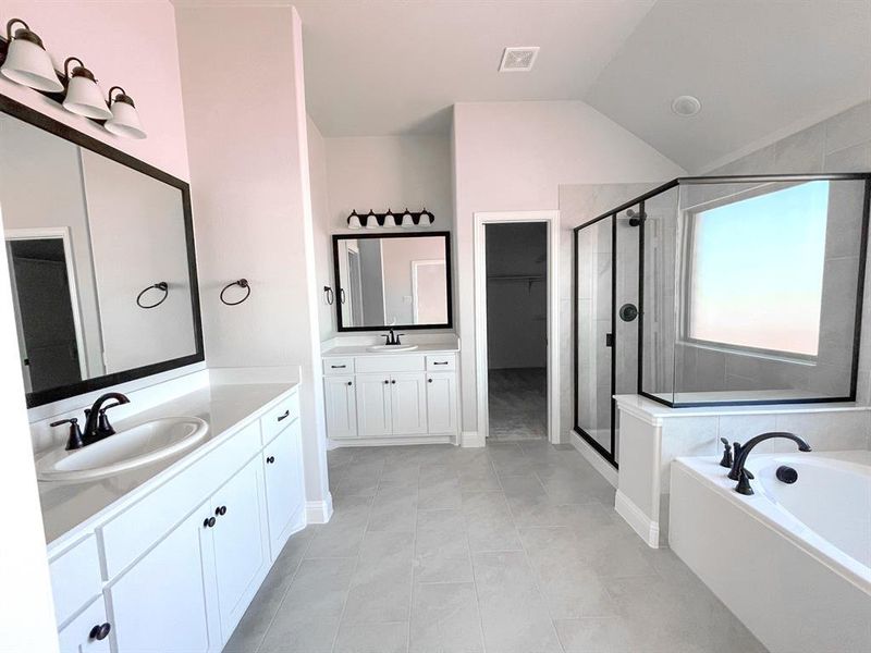 Large primary bathroom with separate toilet room, double vanities, large walk-in shower, garden tub and large walk-in closet