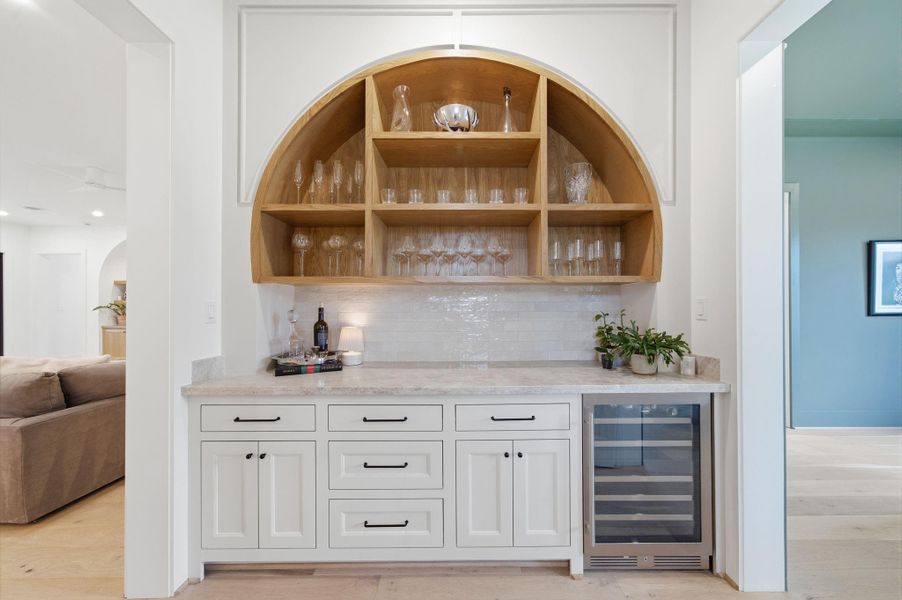 Custom Bar with beautiful woodwork that mirrors the elegant arches in the living room. Custom Bar with beautiful woodwork that mirrors the elegant arches in the living room.