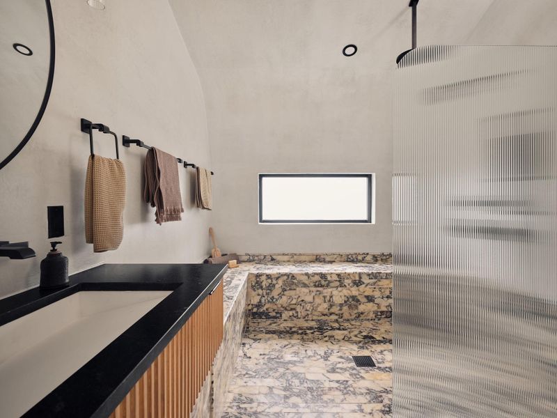 The Calacatta Viola marble tile with its rich, variegatedpalette of deep purples and warm gold veining, the stonebrings a sense of drama and movement to the space andextends seamlessly into the adjacent primary closet. The Calacatta Viola marble tile with its rich, variegatedpalette of deep purples and warm gold veining, the stonebrings a sense of drama and movement to the space andextends seamlessly into the adjacent primary closet.