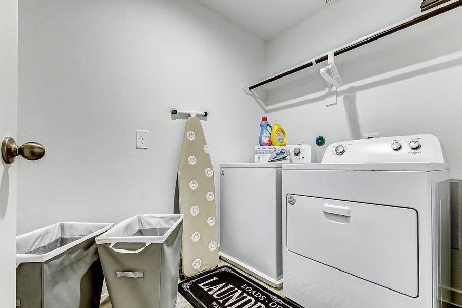 Spacious laundry room equipped with a washer and dryer for added convenience.