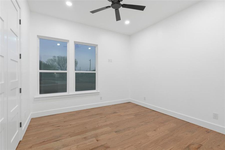 Empty room featuring wood finished floors, a ceiling fan, and recessed lighting