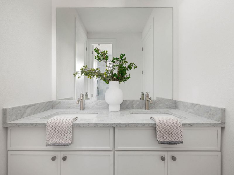 Dual vanity with pristine marble counters offers both function and elegance.