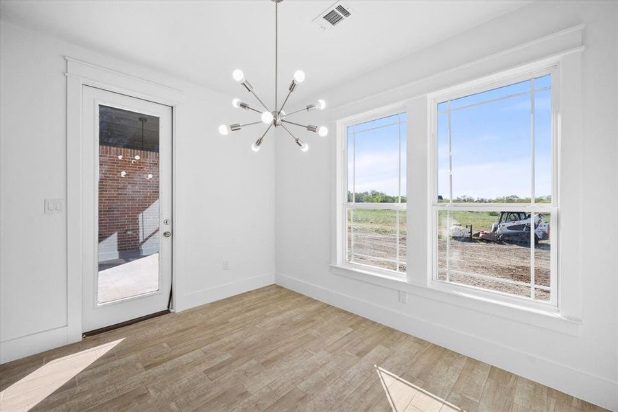 Unfurnished dining area featuring light hardwood / wood-style flooring and a chandelier