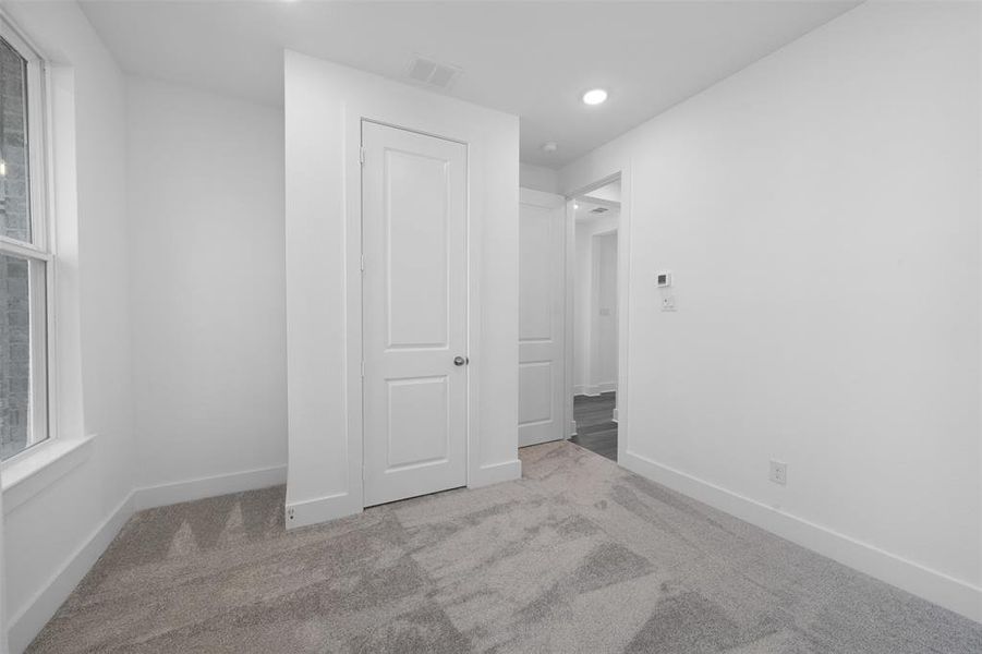 Unfurnished bedroom with light colored carpet