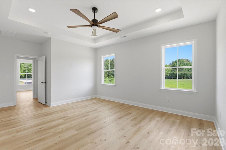 primary bedroom w/ tray ceiling, ensuite full bath, WIC w/ wood shelves! primary bedroom w/ tray ceiling, ensuite full bath, WIC w/ wood shelves!