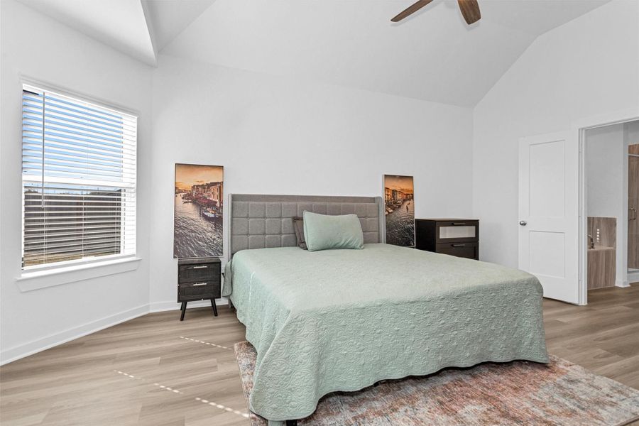This spacious primary bedroom features vaulted ceilings, natural light, and a relaxing layout that creates a peaceful private retreat.
