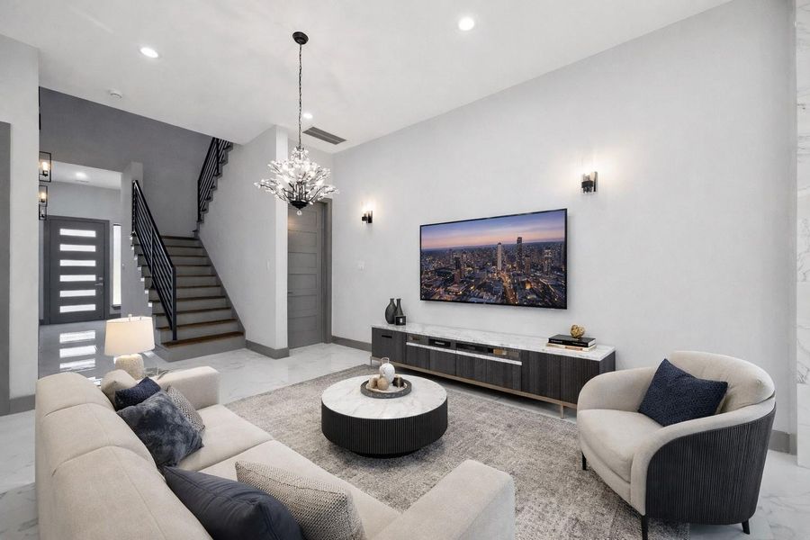 In the entry, bold lighting and sleek sconces create a welcoming atmosphere, complemented by an open design that leads naturally to the staircase and central living areas. *Virtually Staged* In the entry, bold lighting and sleek sconces create a welcoming atmosphere, complemented by an open design that leads naturally to the staircase and central living areas. *Virtually Staged*