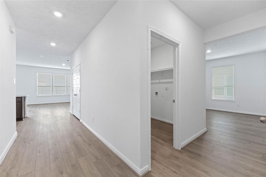 This view showcases the entrance to the Den, laundry room, and entrance to kitchen and Great Room.