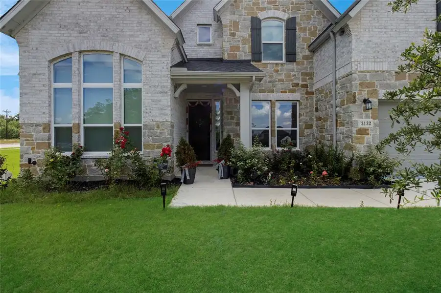Exterior showcasing a blend of light-colored brick and natural stone accents