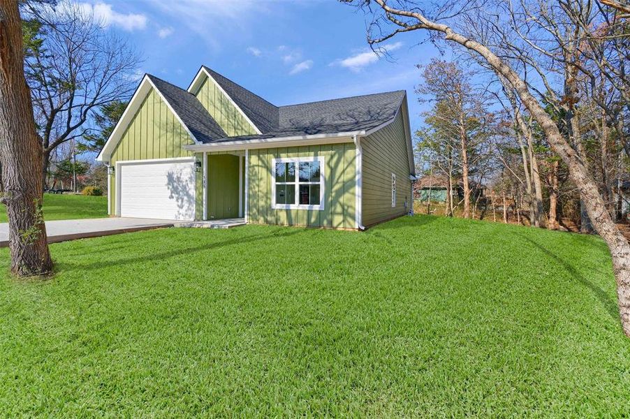 View of front of property featuring a front yard and a garage