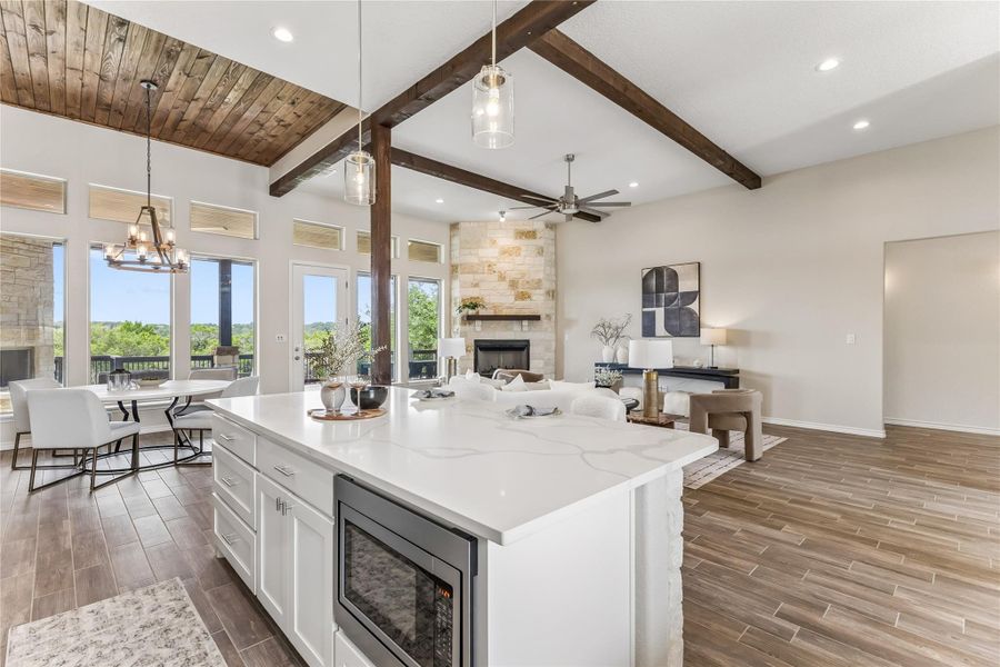 An open-concept living area with vaulted wood-plank ceilings and a stone fireplace invites comfort and natural light.