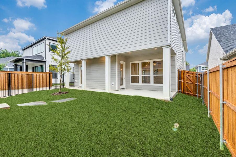 Rear view of house with a patio and a yard