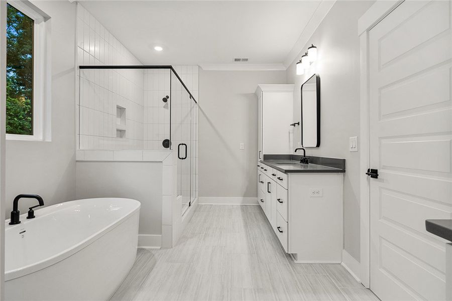 A modern primary bathroom features a standalone tu A modern primary bathroom features a standalone tu