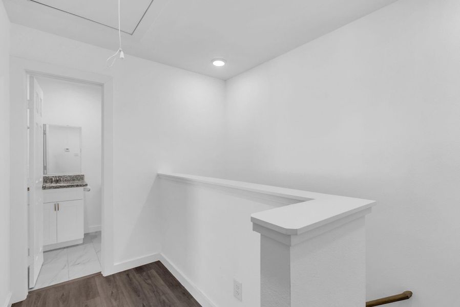Landing at the top of the stairs leads to full bath with tub shower combo granite countertop, mirror and white cabinetry. Landing at the top of the stairs leads to full bath with tub shower combo granite countertop, mirror and white cabinetry.