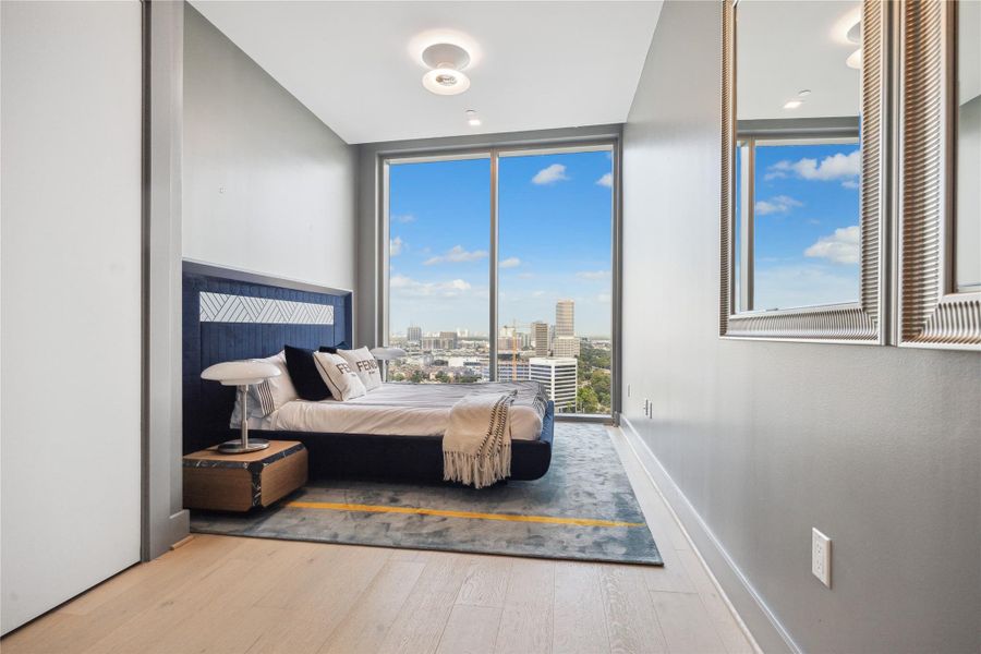 Secondary bedroom with to ceiling windows and walk in closet.