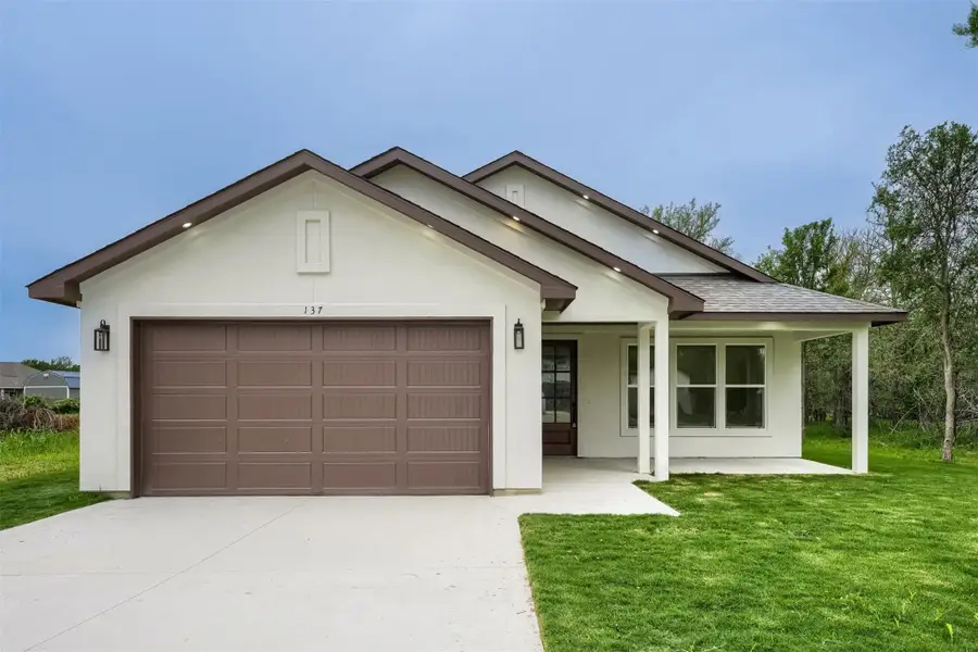 Single-story residence featuring a two-car garage, covered porch, and a white stucco exterior with brown trim accents