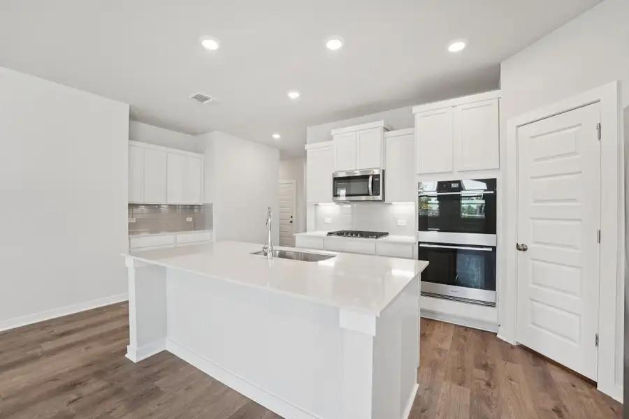 A kitchen with white cabinets.