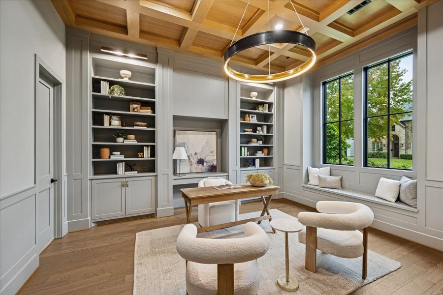 Coffered white oak ceilings introduce craftsmanship and dimension, while full-height windows frame lush green views that make workdays feel calmer. Custom built-ins blend seamlessly with wainscoting for a tailored, polished look, and a window seat creates a comfortable reading nook. *Previous Project*