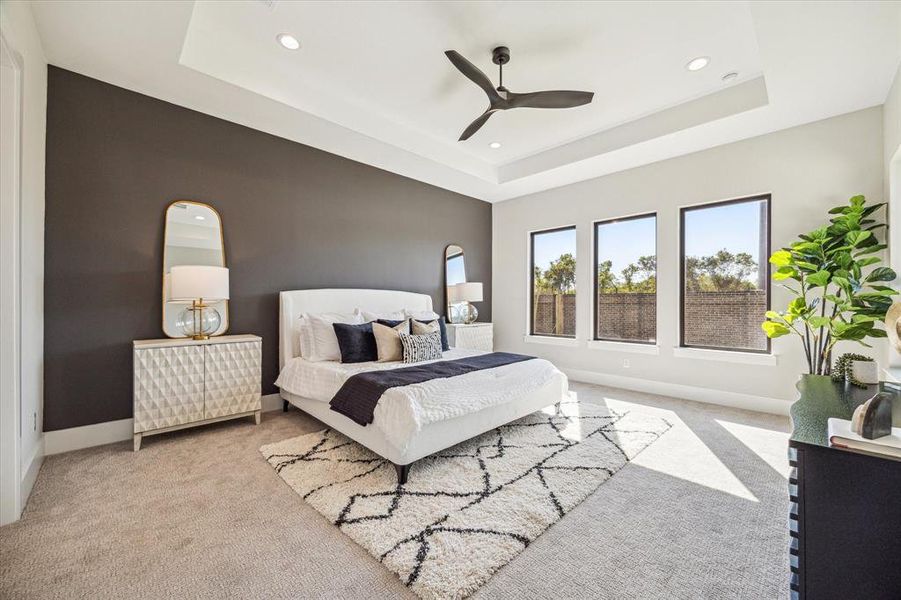 Primary bedroom with coffered ceiling and painted accent wall.