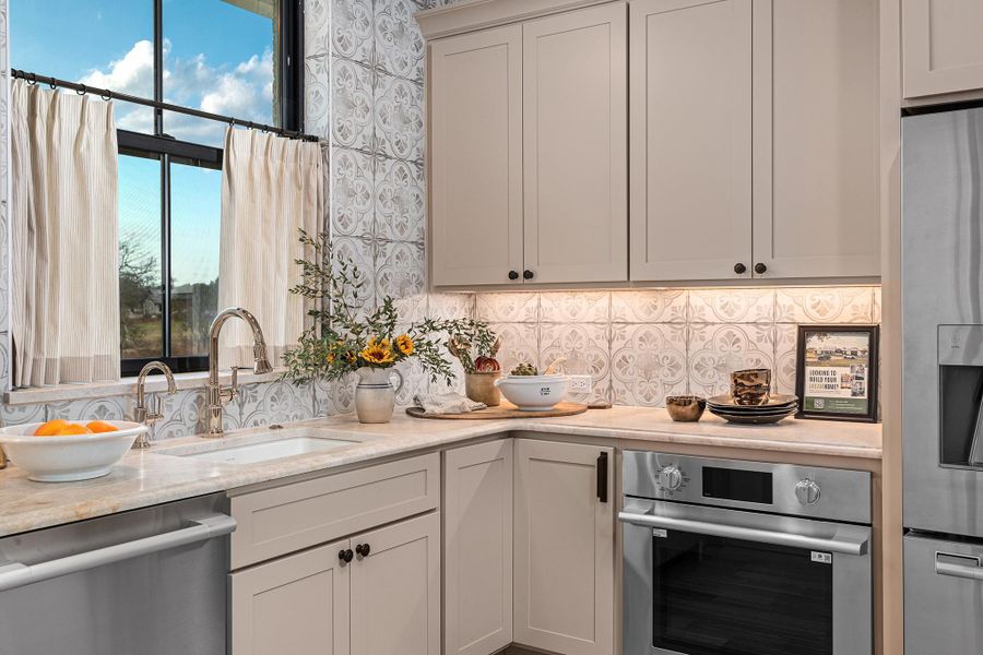 Caterer Kitchen with stainless steel appliances, light stone counters, and tasteful backsplash