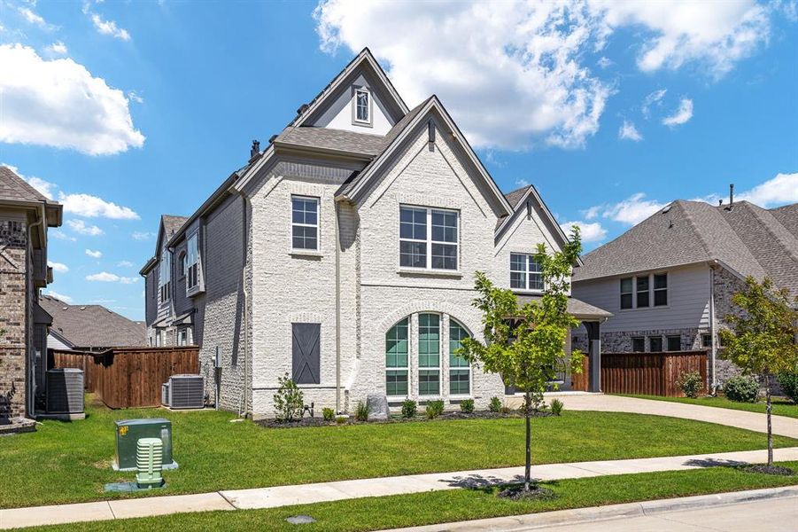 View of front of home with central AC and a front lawn