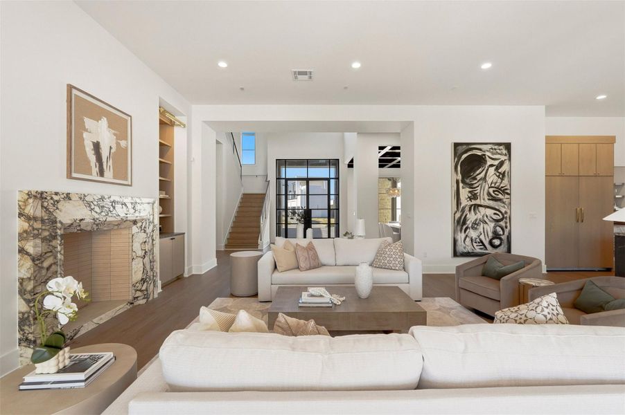 The breathtaking foyer opens up to a spacious living room. It features a sculptural, marble-clad gas fireplace that anchors the living space. The breathtaking foyer opens up to a spacious living room. It features a sculptural, marble-clad gas fireplace that anchors the living space.