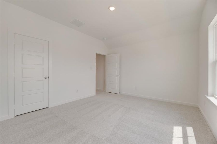 Unfurnished room with lofted ceiling, light colored carpet, and recessed lighting Unfurnished room with lofted ceiling, light colored carpet, and recessed lighting
