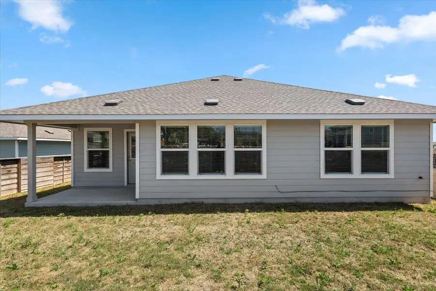 Rear view of house with a patio area and roof with shingles