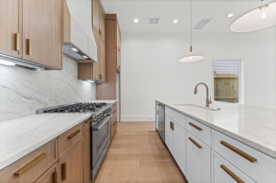 The chef's kitchen showcases an upgraded appliance package, including a professional-style gas range.