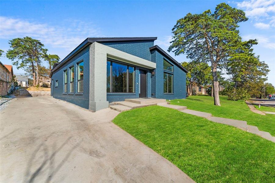 View of front of home with a front yard and brick siding