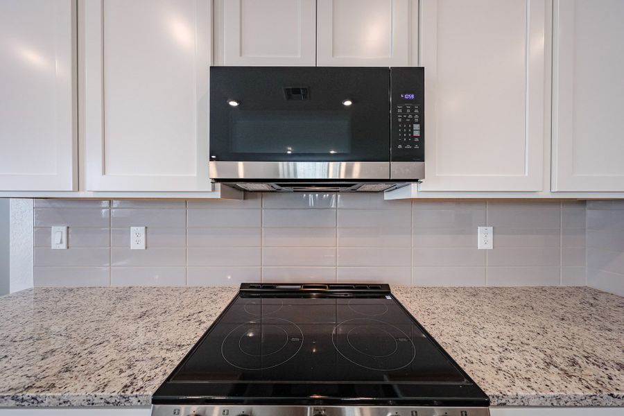 A kitchen with white cabinets.