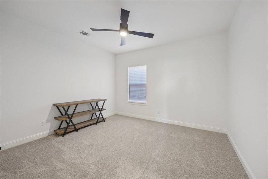 Unfurnished room featuring light colored carpet and a ceiling fan Unfurnished room featuring light colored carpet and a ceiling fan
