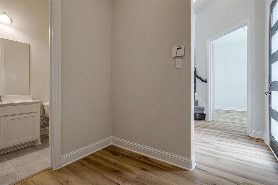 Hall with a wealth of natural light, sink, and light hardwood / wood-style floors